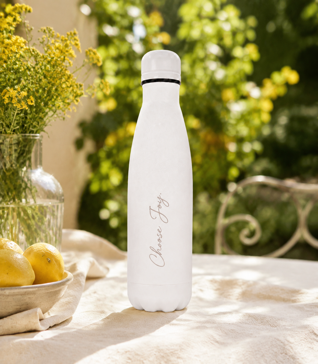 White 500ml personalised stainless steel water bottle engraved “Choose Joy” on a sunlit garden table with lemons and yellow flowers | Willys Bottles